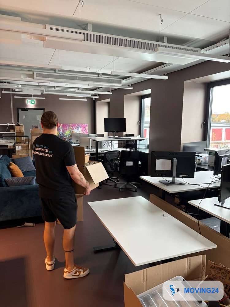 Moving24 töötaja kannab kontorikolimisel kasti